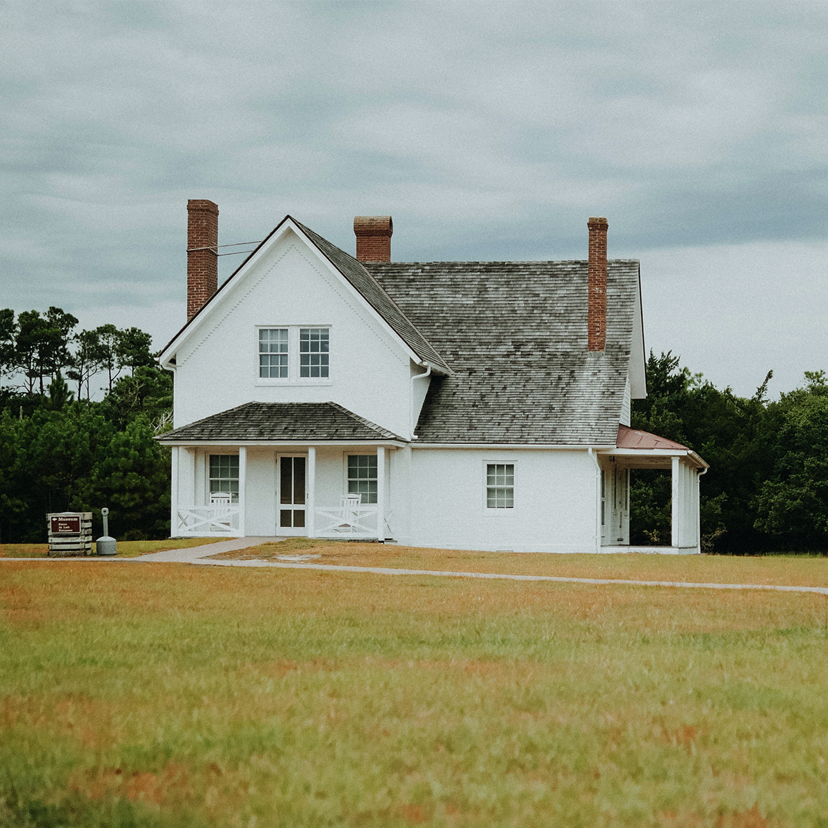 A white detached house in the middle of a field